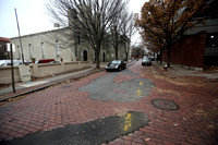 brick/cobblestone streets are being patched with asphalt